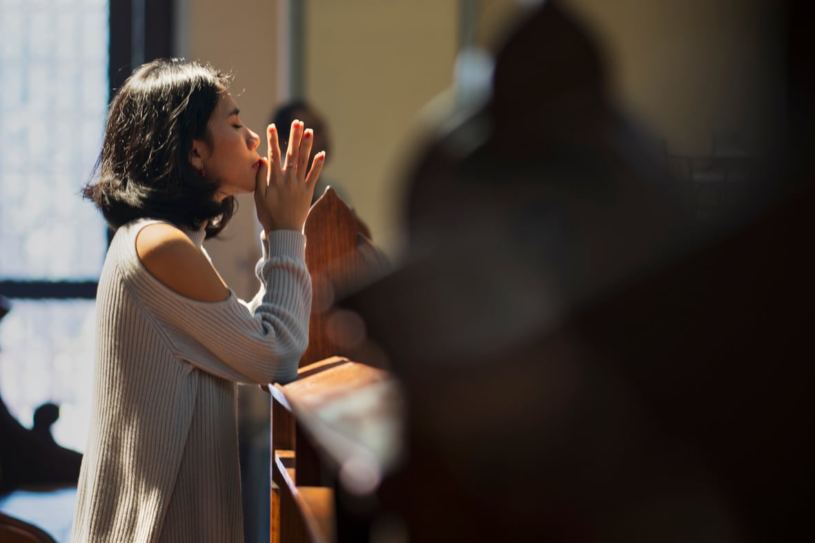 Christian Asian Woman Prays in the Church